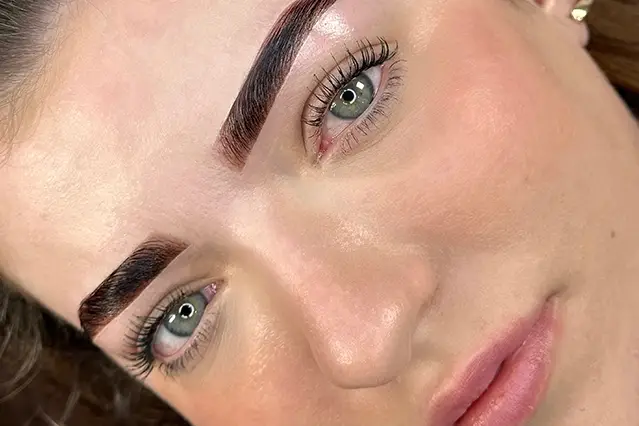 Close-up of a woman's perfectly groomed eyebrows and natural makeup.