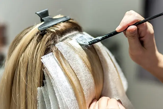 Hair being colored with foils in a beauty salon.
