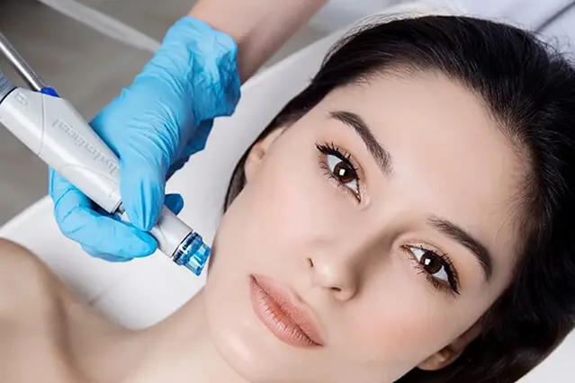 Woman receiving a facial treatment with a HydraFacial device.